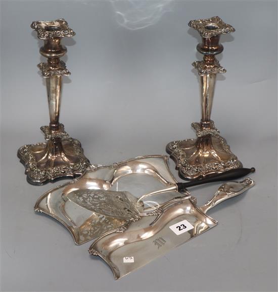 A pair of plated candlesticks, a crumb scoop and a presentation trowel